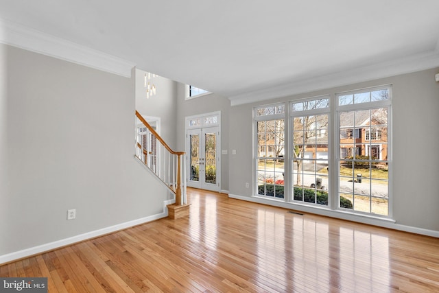 interior space with light wood finished floors, visible vents, baseboards, stairway, and ornamental molding