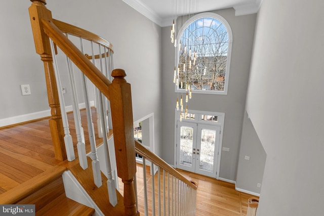 entryway featuring french doors, stairs, baseboards, and wood finished floors