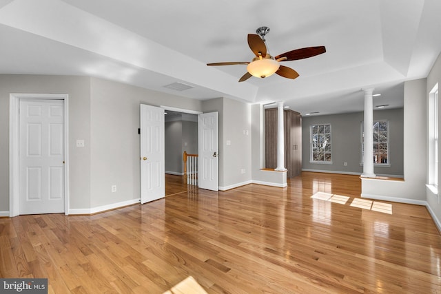 unfurnished living room with visible vents, ceiling fan, baseboards, decorative columns, and light wood-style floors