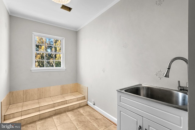 kitchen featuring ornamental molding, baseboards, and a sink