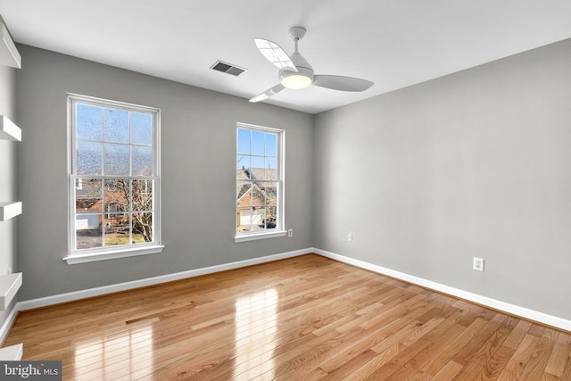 unfurnished room with a ceiling fan, light wood-style flooring, baseboards, and visible vents