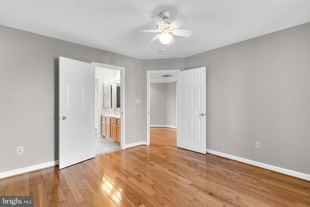 unfurnished bedroom with ceiling fan, light wood-type flooring, and baseboards