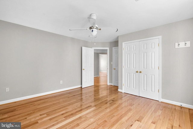 unfurnished bedroom with a ceiling fan, baseboards, light wood-type flooring, and a closet