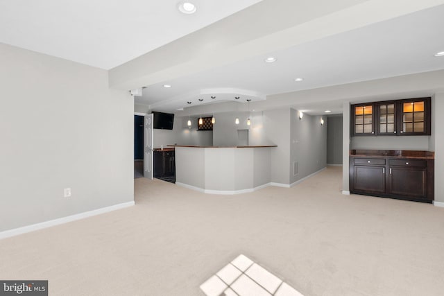 unfurnished living room with recessed lighting, baseboards, light colored carpet, and bar