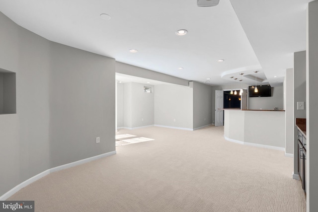 unfurnished living room with light carpet, recessed lighting, and baseboards