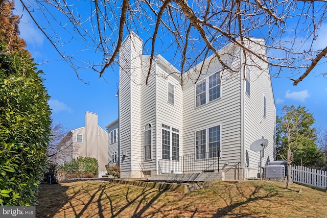 view of home's exterior with a patio, a chimney, and fence