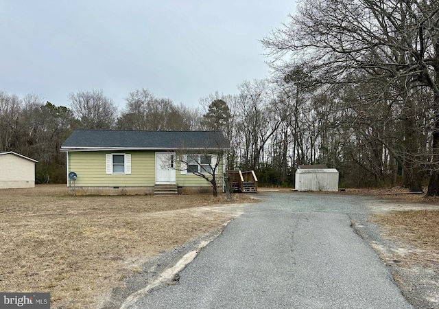 view of front of property with a storage shed