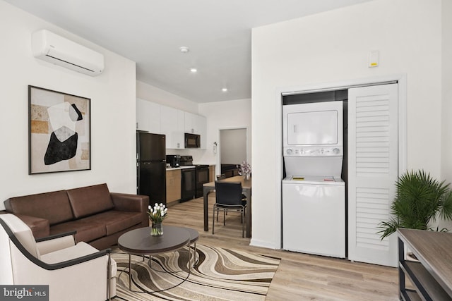 living room featuring stacked washing maching and dryer, a wall mounted air conditioner, and light hardwood / wood-style floors