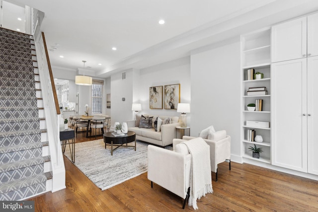 living room featuring ornamental molding and dark wood-type flooring