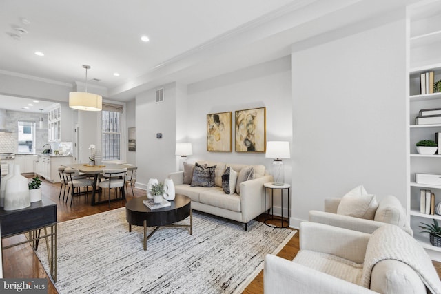 living room with crown molding and hardwood / wood-style floors