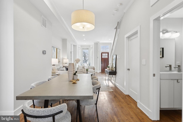 dining room with ceiling fan, crown molding, sink, and hardwood / wood-style flooring