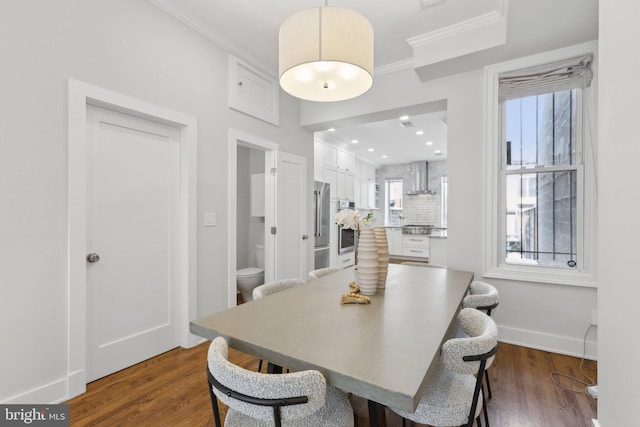 dining space featuring ornamental molding and dark hardwood / wood-style flooring