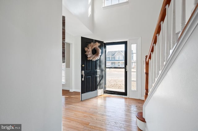 entrance foyer with a towering ceiling and light hardwood / wood-style flooring