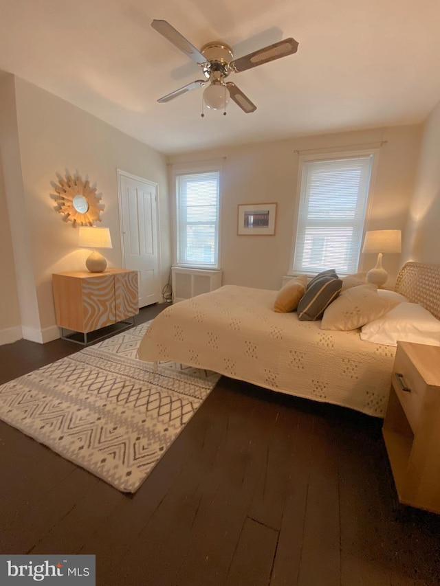 bedroom with radiator, ceiling fan, a closet, and dark hardwood / wood-style floors