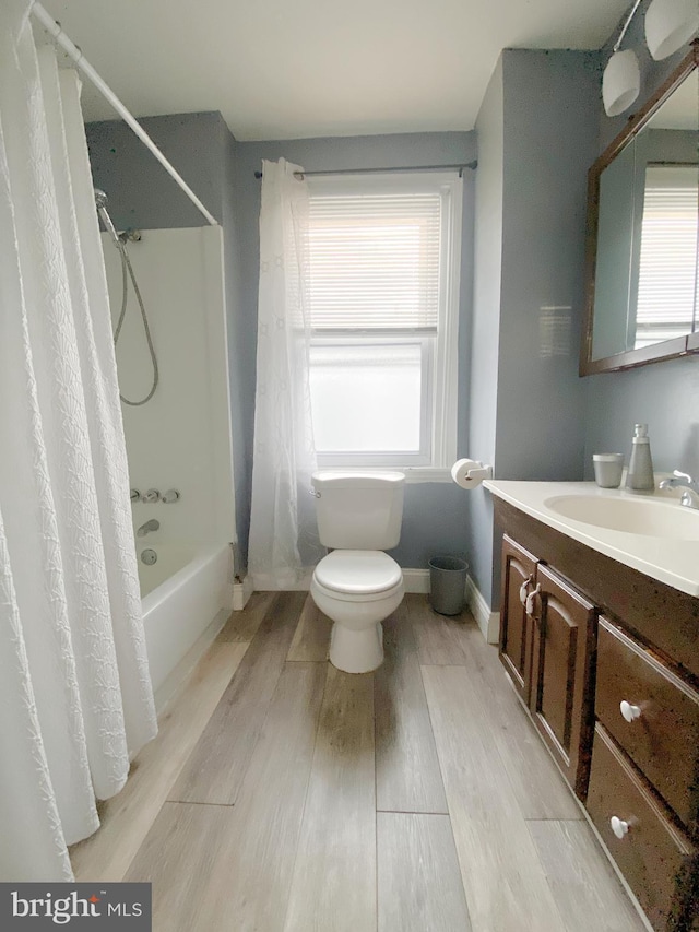 full bathroom featuring hardwood / wood-style floors, vanity, toilet, and shower / tub combo with curtain