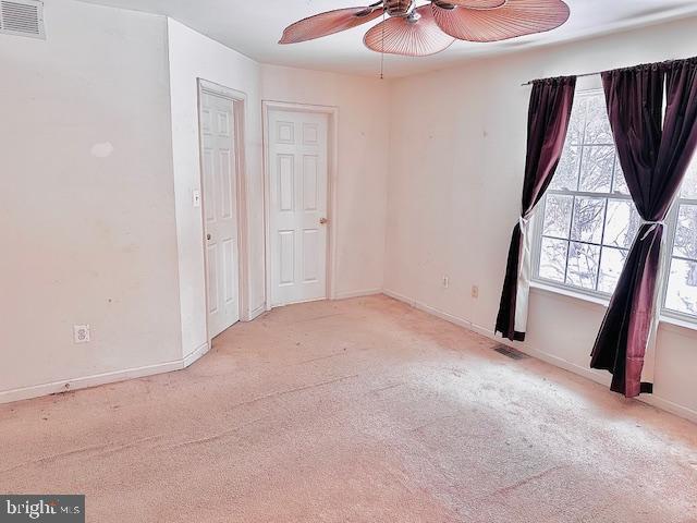 spare room featuring ceiling fan and light colored carpet