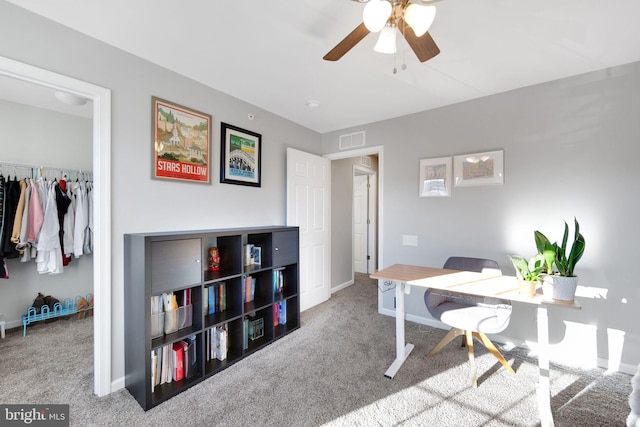 office space featuring light carpet and ceiling fan