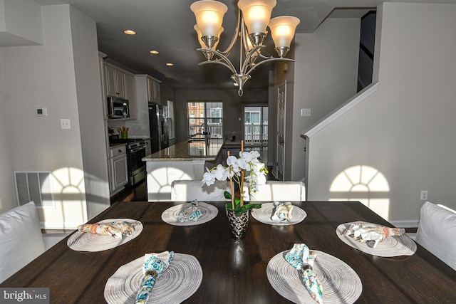 dining area featuring sink and a notable chandelier