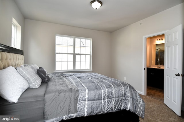 bedroom featuring multiple windows, ensuite bath, and carpet