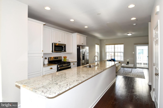 kitchen featuring appliances with stainless steel finishes, sink, a center island with sink, and white cabinets