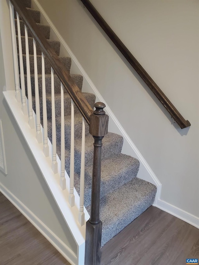 stairs featuring hardwood / wood-style floors