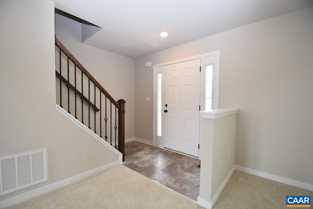 foyer entrance featuring light colored carpet