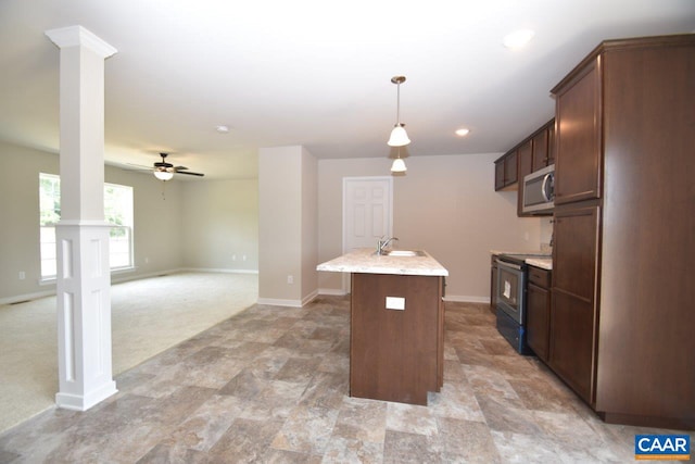 kitchen featuring pendant lighting, sink, electric range, ceiling fan, and an island with sink