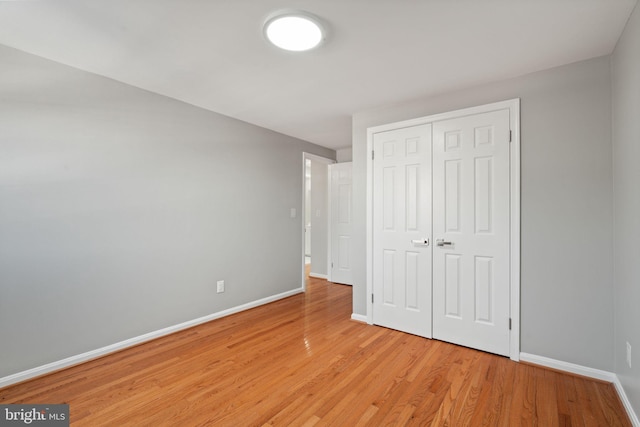 unfurnished bedroom featuring light wood-type flooring and a closet