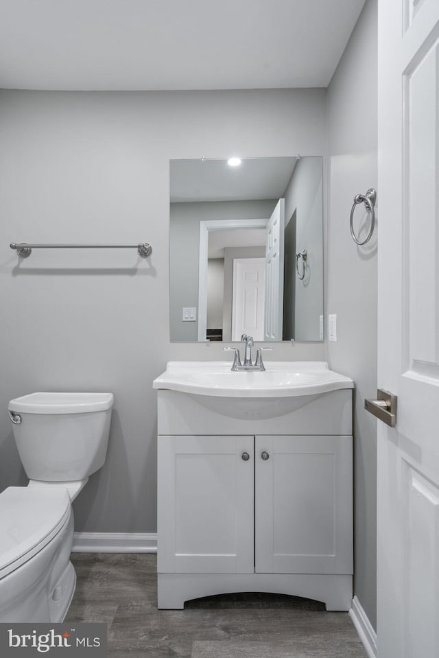 bathroom with hardwood / wood-style floors, vanity, and toilet