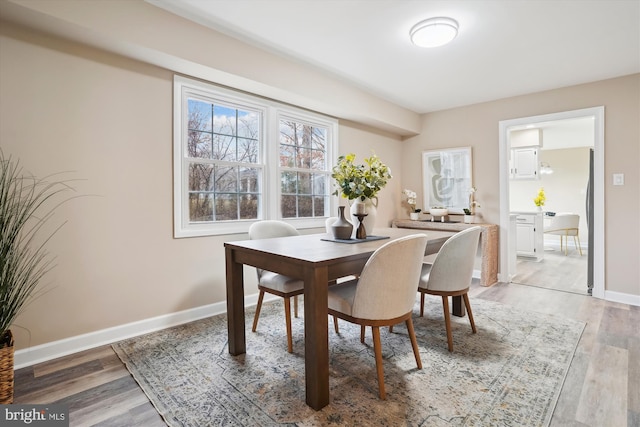 dining area featuring light wood-type flooring and baseboards