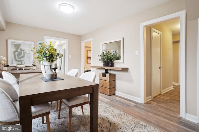 dining area with baseboards and light wood-style floors