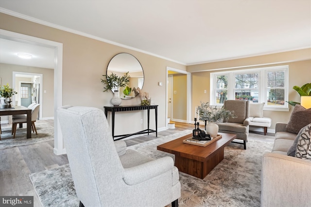 living area featuring ornamental molding, wood finished floors, and a healthy amount of sunlight