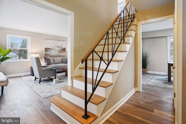 staircase featuring baseboards and wood finished floors