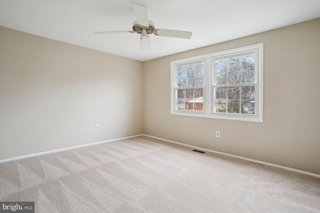 unfurnished room featuring baseboards, ceiling fan, visible vents, and light colored carpet