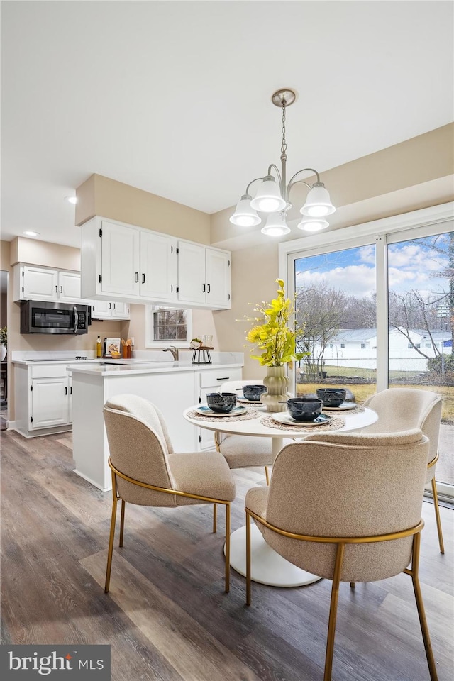 dining space featuring light wood-style floors and a notable chandelier