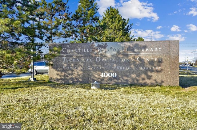 community / neighborhood sign featuring a lawn