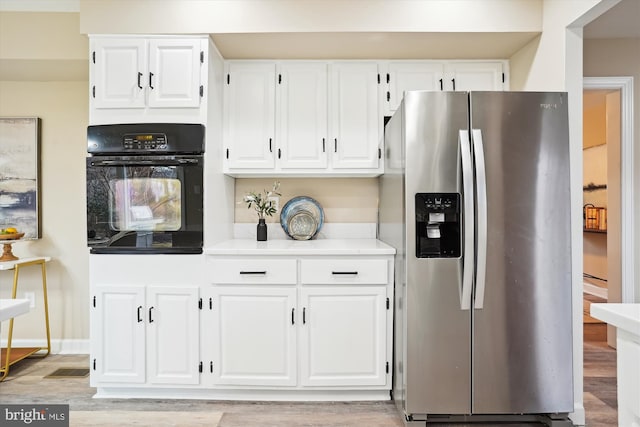 kitchen featuring white cabinetry, black oven, light countertops, light wood-type flooring, and stainless steel fridge with ice dispenser