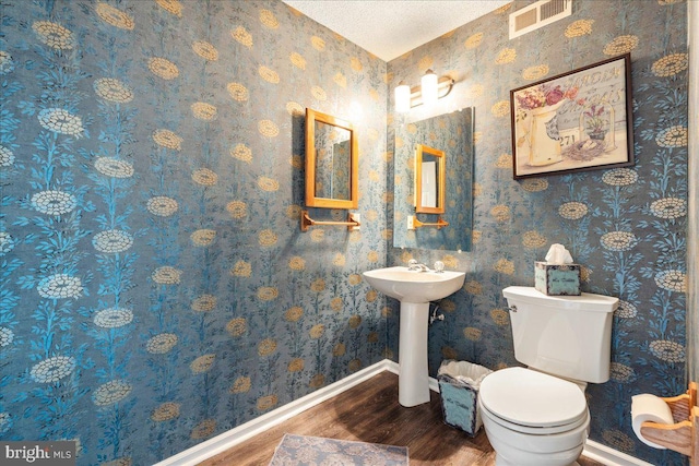 bathroom featuring hardwood / wood-style flooring, sink, a textured ceiling, and toilet