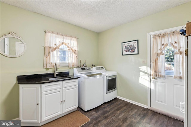 laundry area featuring separate washer and dryer, sink, dark hardwood / wood-style flooring, cabinets, and a textured ceiling