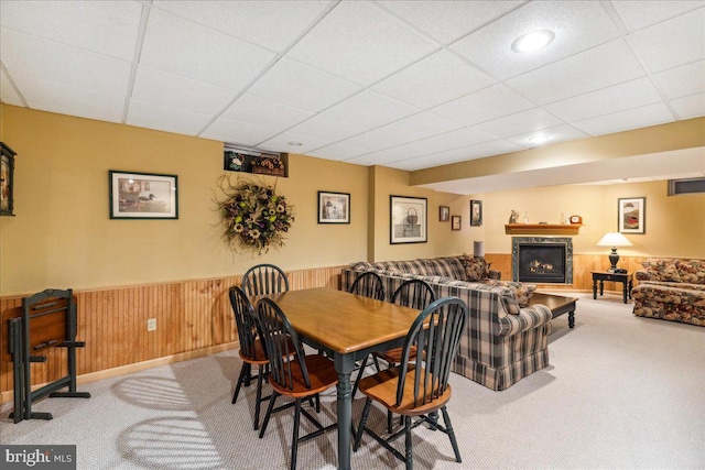 carpeted dining space with a drop ceiling