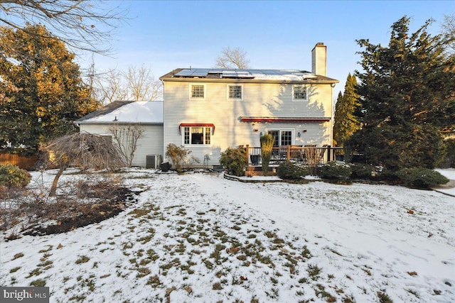 snow covered rear of property featuring a deck