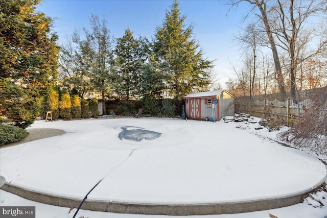 snowy yard featuring a storage shed