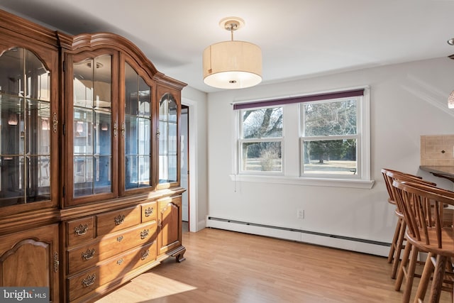 dining room with light wood finished floors and baseboard heating