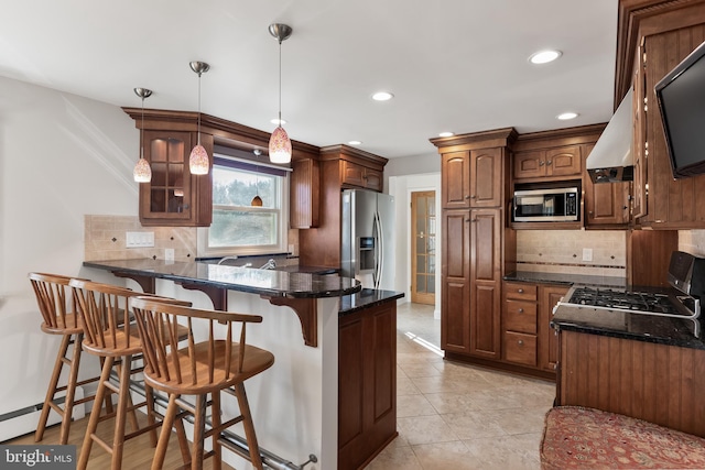 kitchen featuring decorative light fixtures, a breakfast bar area, glass insert cabinets, and built in microwave