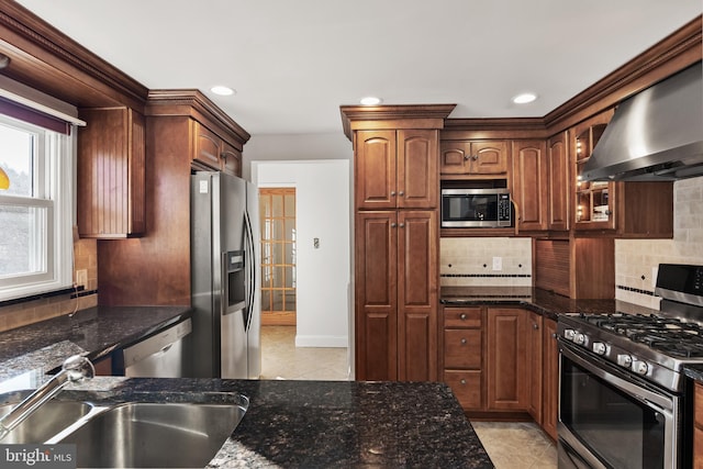 kitchen with stainless steel appliances, glass insert cabinets, a sink, ventilation hood, and dark stone counters