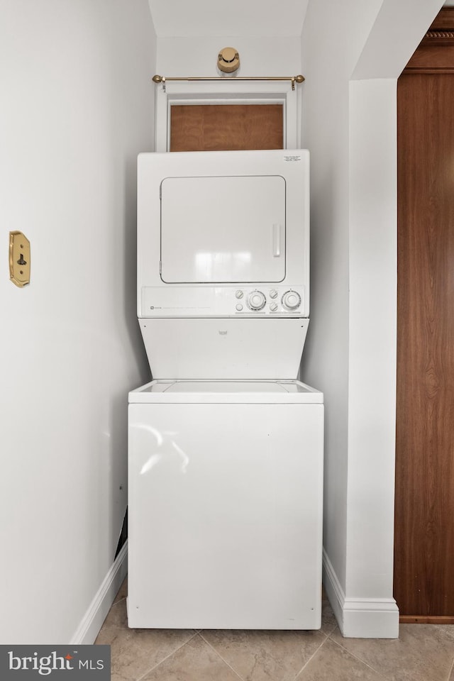 washroom with laundry area, stacked washing maching and dryer, and baseboards