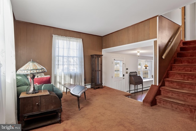 living area featuring carpet floors, a wealth of natural light, a baseboard heating unit, and stairway