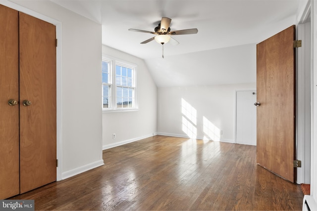 additional living space with baseboards, ceiling fan, dark wood-style flooring, vaulted ceiling, and a baseboard heating unit