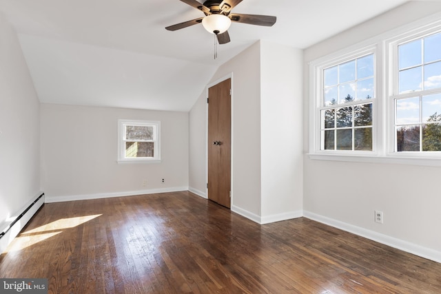 unfurnished bedroom with vaulted ceiling, dark wood-type flooring, baseboard heating, and baseboards