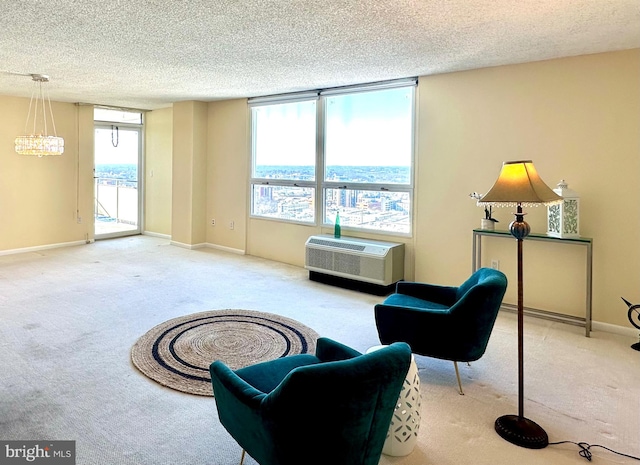 living area with carpet, a textured ceiling, a chandelier, and an AC wall unit